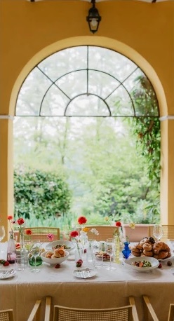 A brunch table set under an arched window