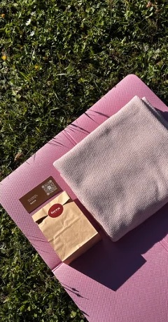 A mat, a towel and a terra kit in the grass
