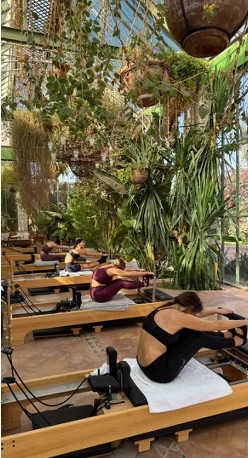 Reformer Pilates in a garden full of plants